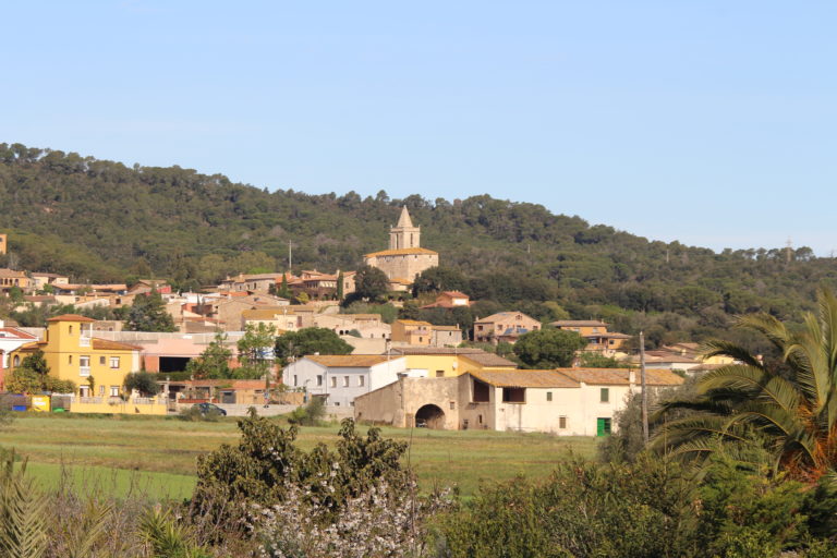 Mont-ras a primer pla i amb l'església al fons