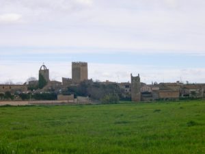 poble i església, a primer pla un camp verd