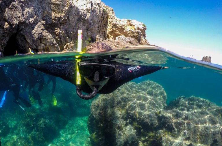 A primer pla kayak pel riu ter amb un noi i una noia, semblen joves. i a darrera un altre kayak amb una parella, semblen els pares