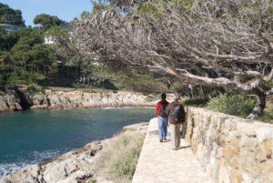 dos nois caminant pel camñi de ronda i al costat esquerra la cala d'aiguafreda