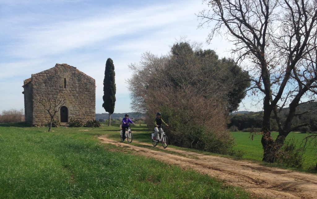 noia en bicicleta que va per un camí asfaltat cap a Peratallada