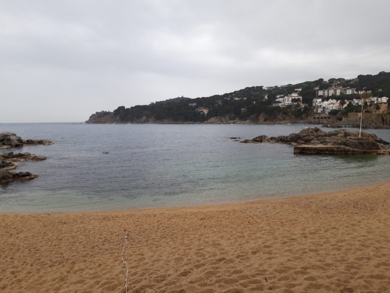 vista des de dalt del cap de Begur. dia amb boira però amb un cel ben blau, a sota la cala d'Aiguablava amb boira