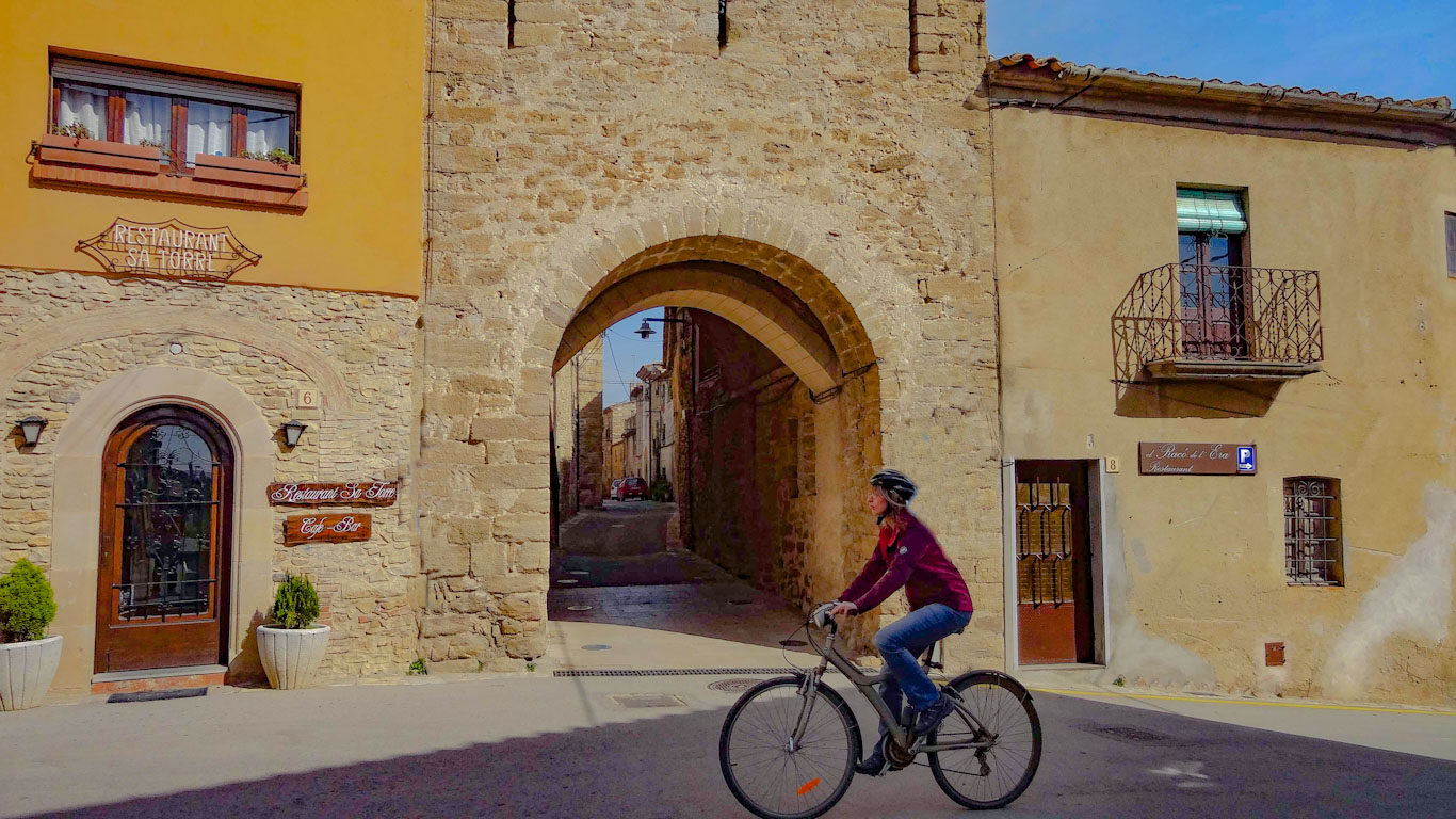 noia en bicicleta que va per un camí asfaltat cap a Peratallada