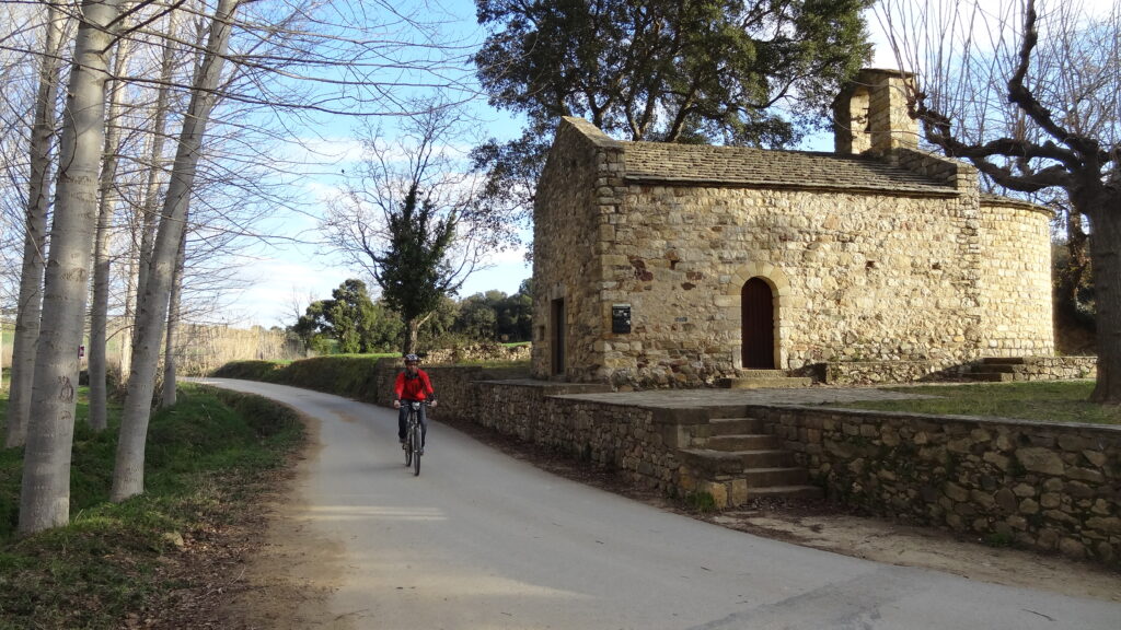 noia en bicicleta que va per un camí asfaltat cap a Peratallada