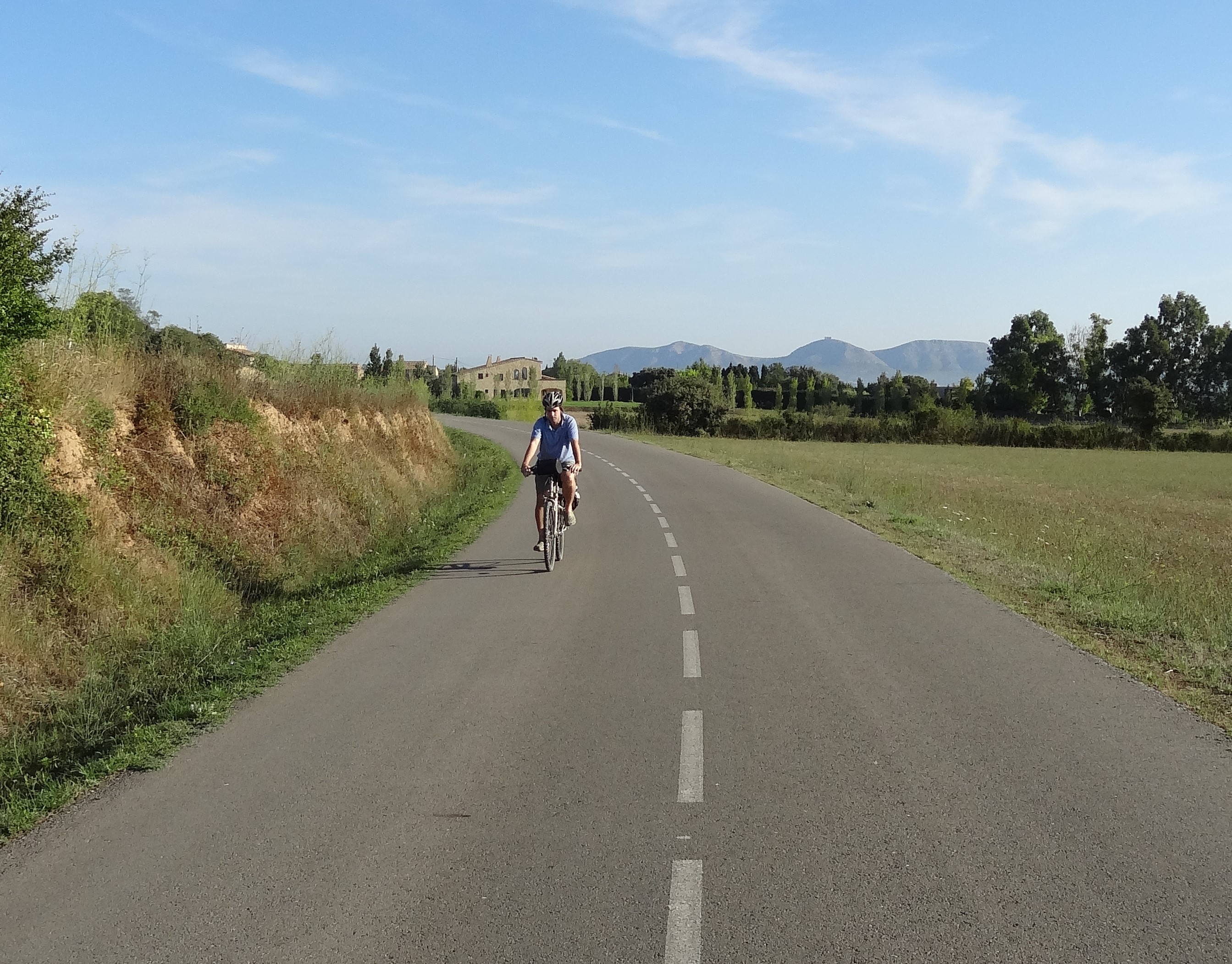 noia en bicicleta que va per un camí asfaltat cap a Peratallada