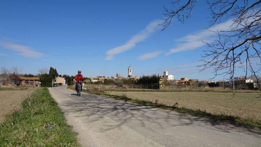 noia en bicicleta que va per un camí asfaltat cap a Peratallada