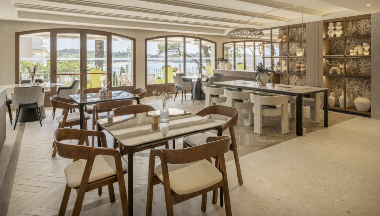 taules d'un restaurant. 5 taules a la sala. Una taula per a quatre persones a primer pla