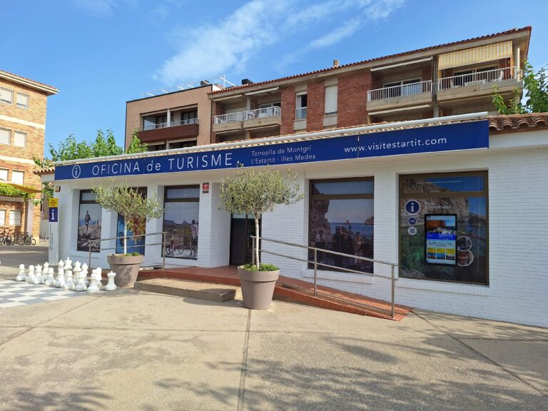 façana oficina de turisme de l'estartit. porta automàtica amb una rampa per accedir a cada banda de la porta